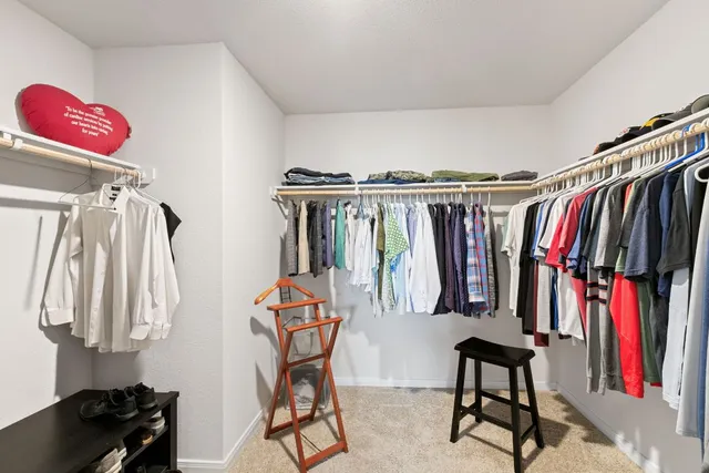 a view of walk in closet with clothes and shoes