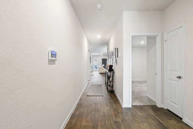 a view of a hallway with wooden floor