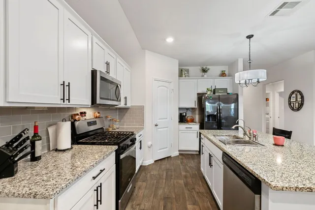 a kitchen with stainless steel appliances granite countertop a sink stove and refrigerator