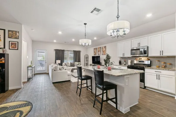 a living room with furniture flat screen tv and wooden floor