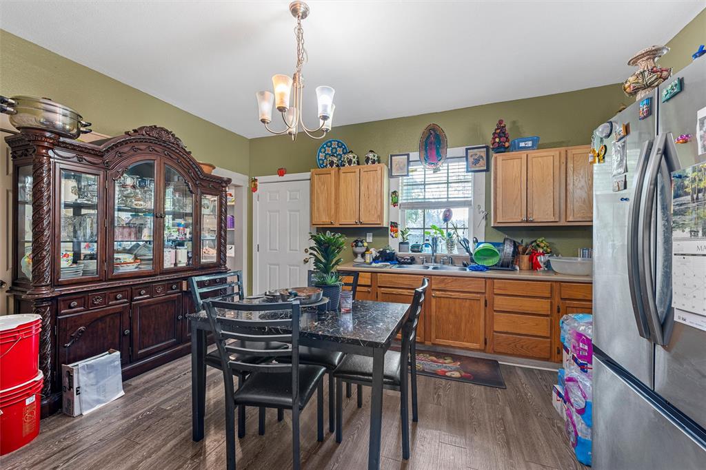 1615 Mitchell Avenue Waco, TX 76708 - Photo 7 of 14 a kitchen with stainless steel appliances granite countertop a stove top oven a refrigerator a dining table and chairs with wooden floor