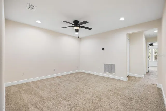 an empty room with a ceiling fan and window
