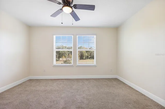 an empty room with a window and a fan