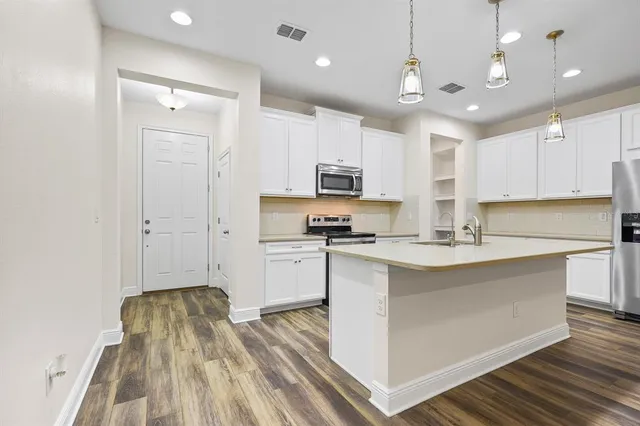 a kitchen with kitchen island a sink stainless steel appliances and cabinets
