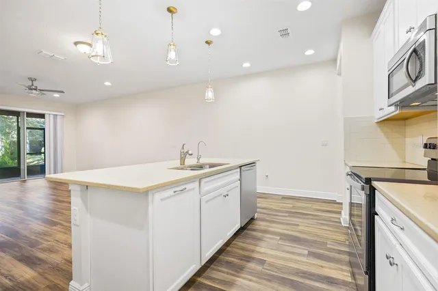 a kitchen with a sink and wooden floor