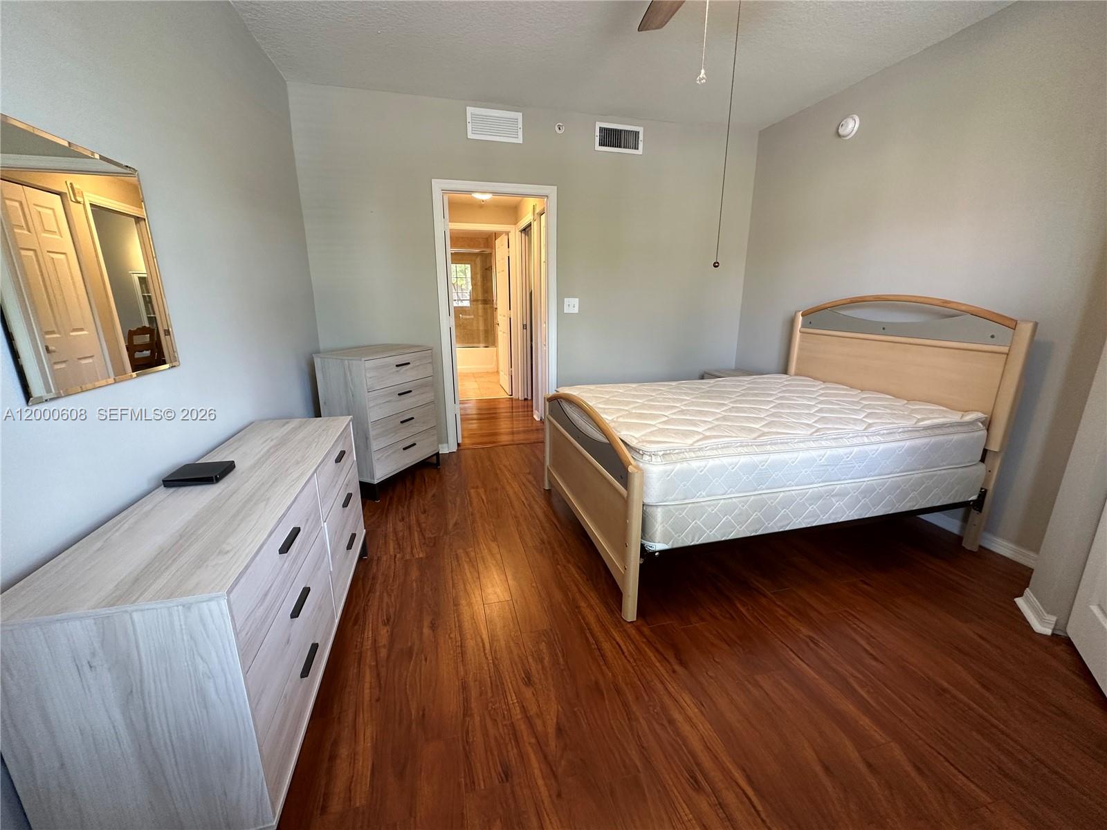 6841 Southwest 44th Street, Unit 209 Miami, FL 33155 - Photo 12 of 20 a bedroom with a bed and wooden floor