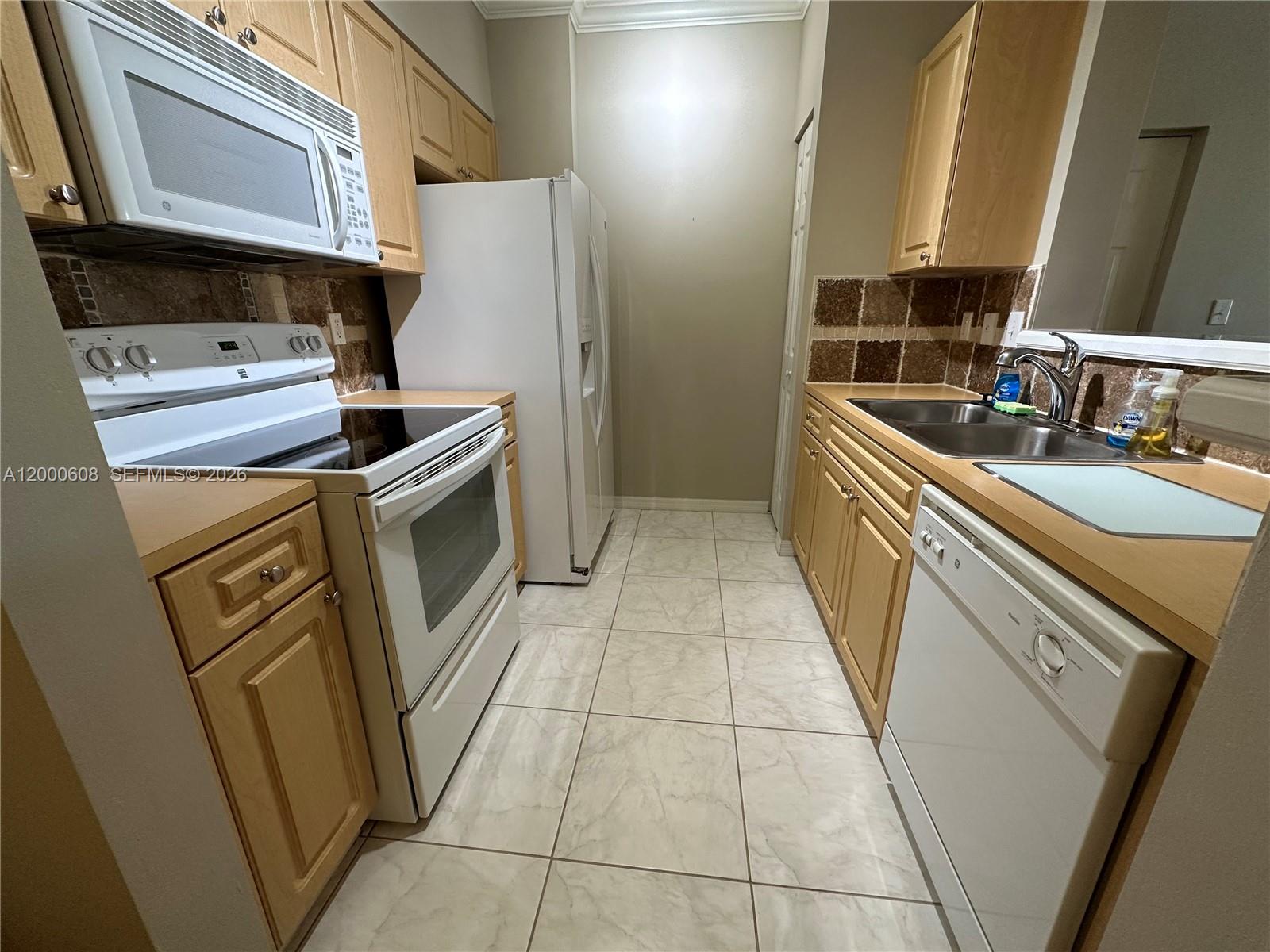 6841 Southwest 44th Street, Unit 209 Miami, FL 33155 - Photo 8 of 20 a kitchen with a sink a stove and a refrigerator