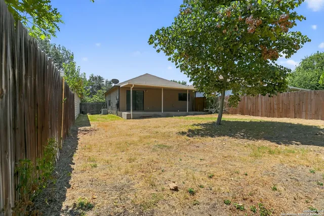 a view of a house with backyard and tree