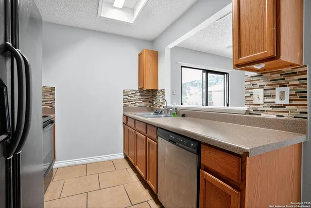 a kitchen with stainless steel appliances granite countertop a sink and a refrigerator