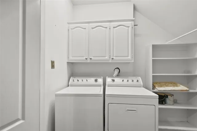 a kitchen with a sink white cabinets and white appliances