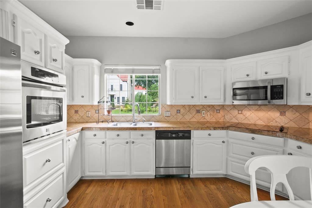 4020 Mediterranean Street Rockwall, TX 75087 - Photo 9 of 29 a kitchen with a sink white cabinets and white appliances