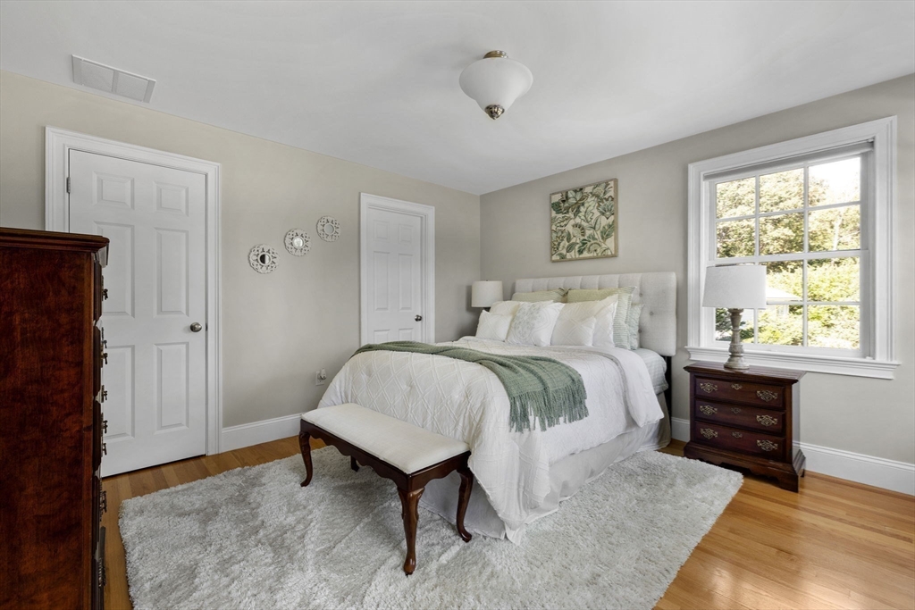 143 Lincoln Street Lexington, MA 02421 - Photo 25 of 42 a spacious bedroom with a bed and a table in it