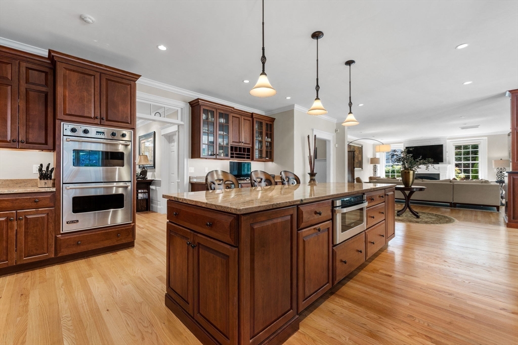 143 Lincoln Street Lexington, MA 02421 - Photo 7 of 42 a kitchen with stainless steel appliances granite countertop wooden cabinets a sink dishwasher a stove and a oven with wooden floor