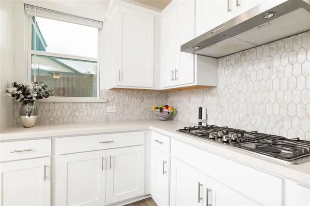a kitchen with white cabinets and appliances