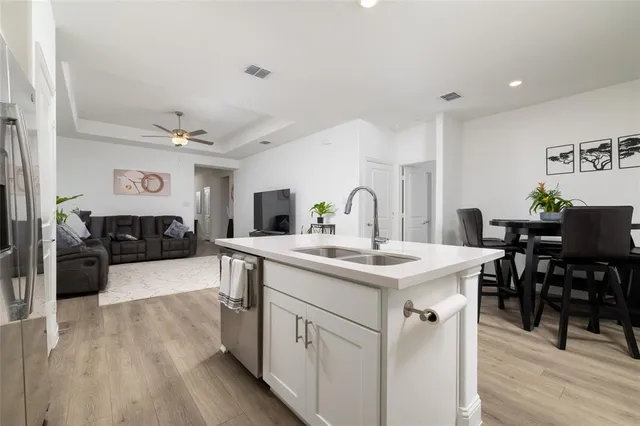 a kitchen with a sink cabinets and wooden floor