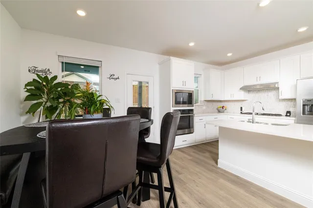 a living room with furniture a potted plant and a kitchen view