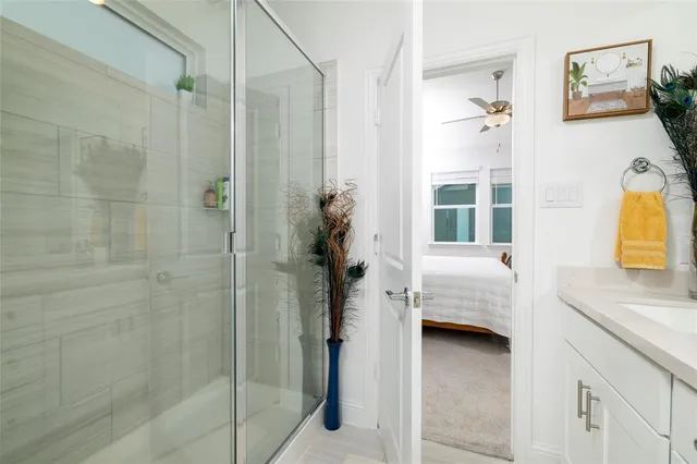 a en suite bathroom with a granite countertop sink a mirror a bathtub and shower
