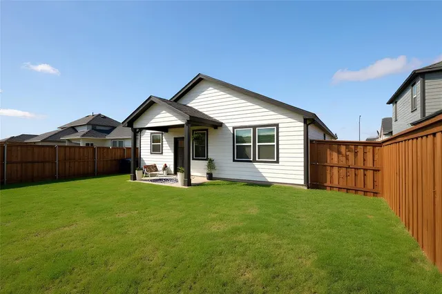 a front view of a house with yard porch and wooden fence