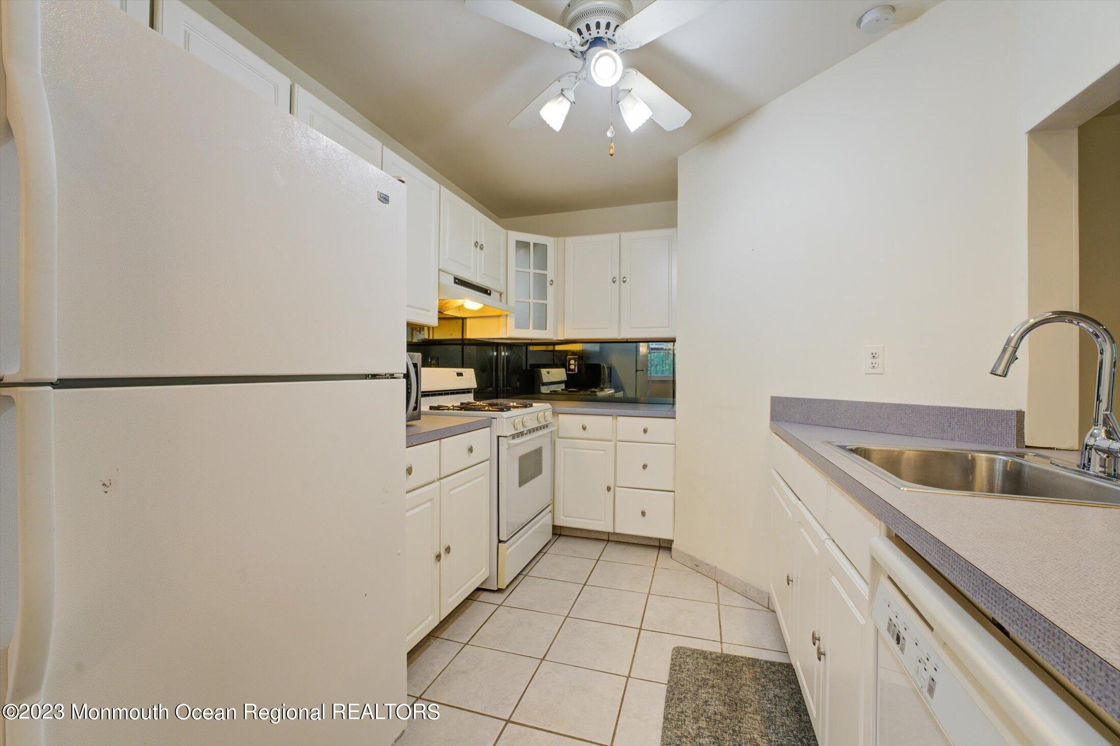 481 Hawthorne Place Morganville, NJ 07751 - Photo 12 of 26 a kitchen with cabinets a sink and appliances