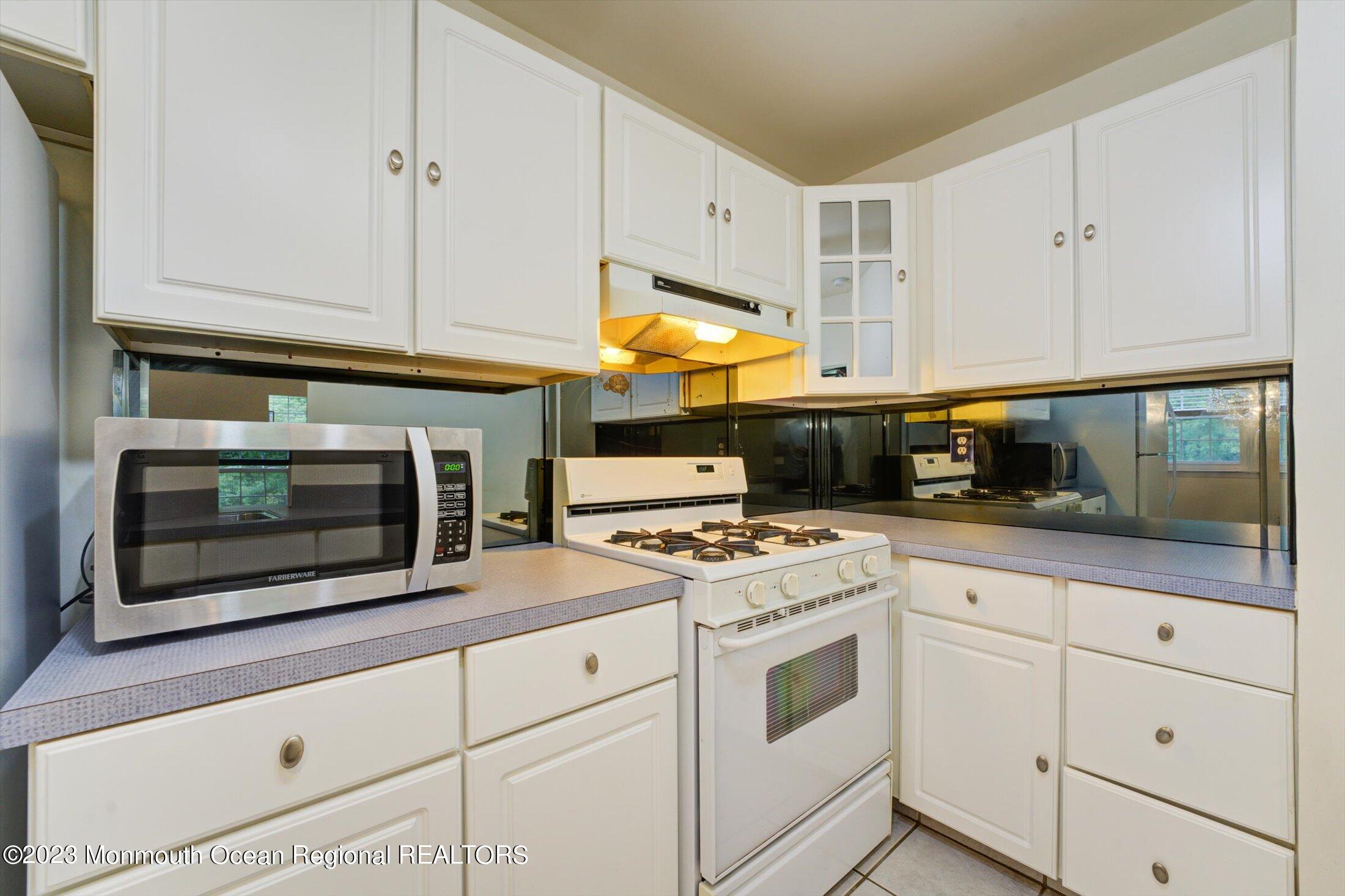481 Hawthorne Place Morganville, NJ 07751 - Photo 14 of 26 a kitchen with white cabinets and appliances