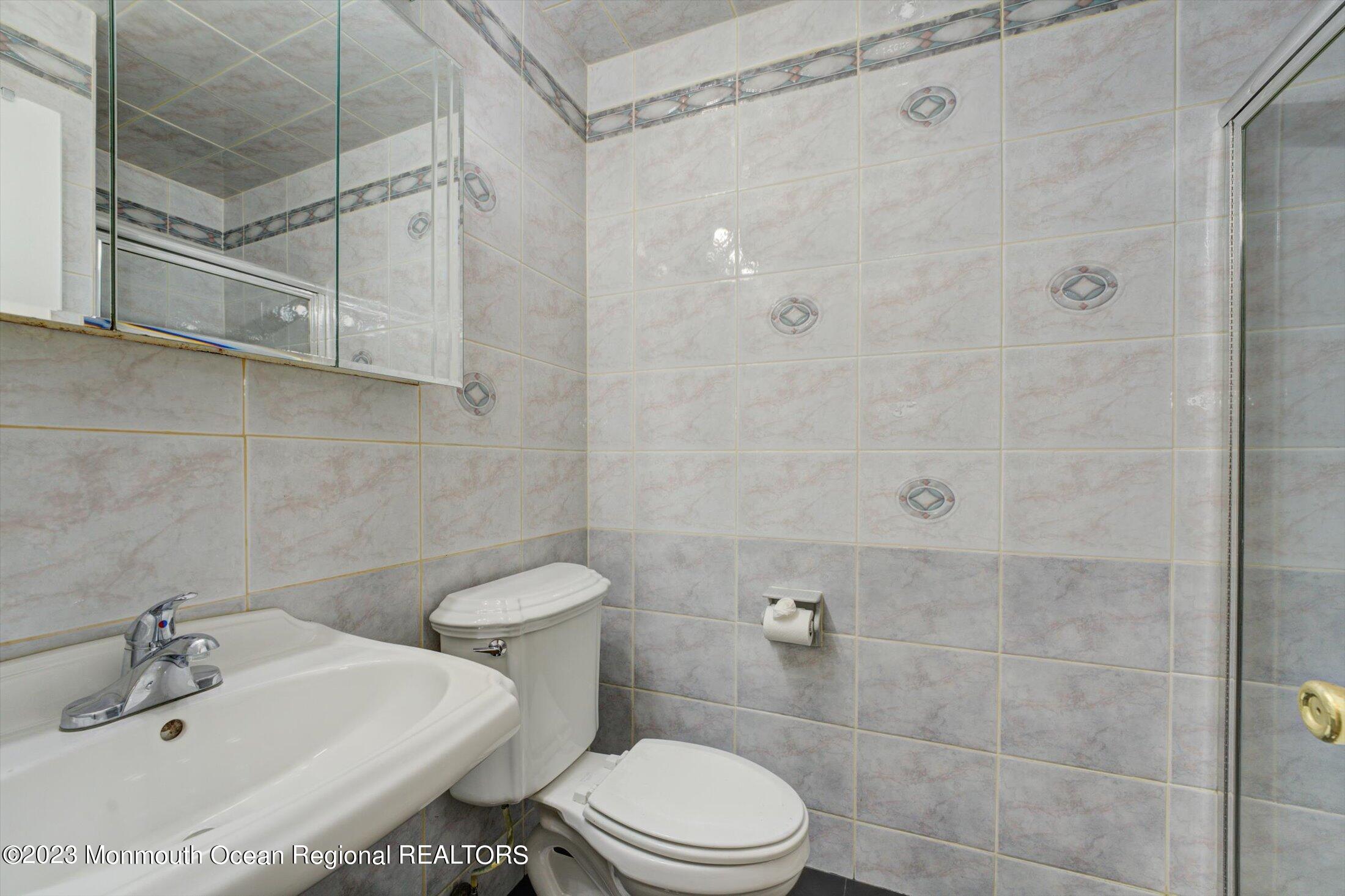 481 Hawthorne Place Morganville, NJ 07751 - Photo 16 of 26 a bathroom with a sink a toilet and shower