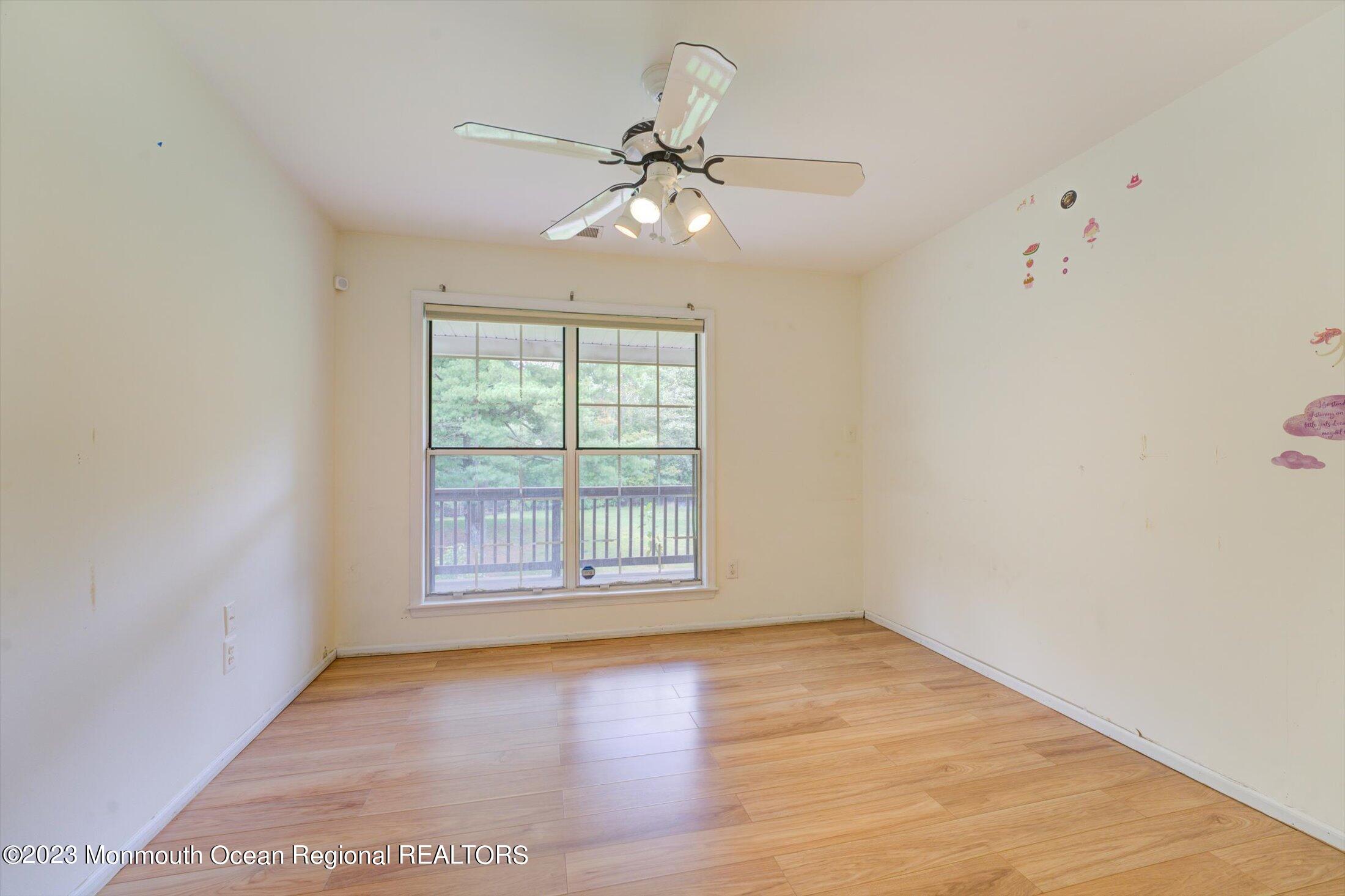481 Hawthorne Place Morganville, NJ 07751 - Photo 18 of 26 an empty room with wooden floor chandelier fan and windows