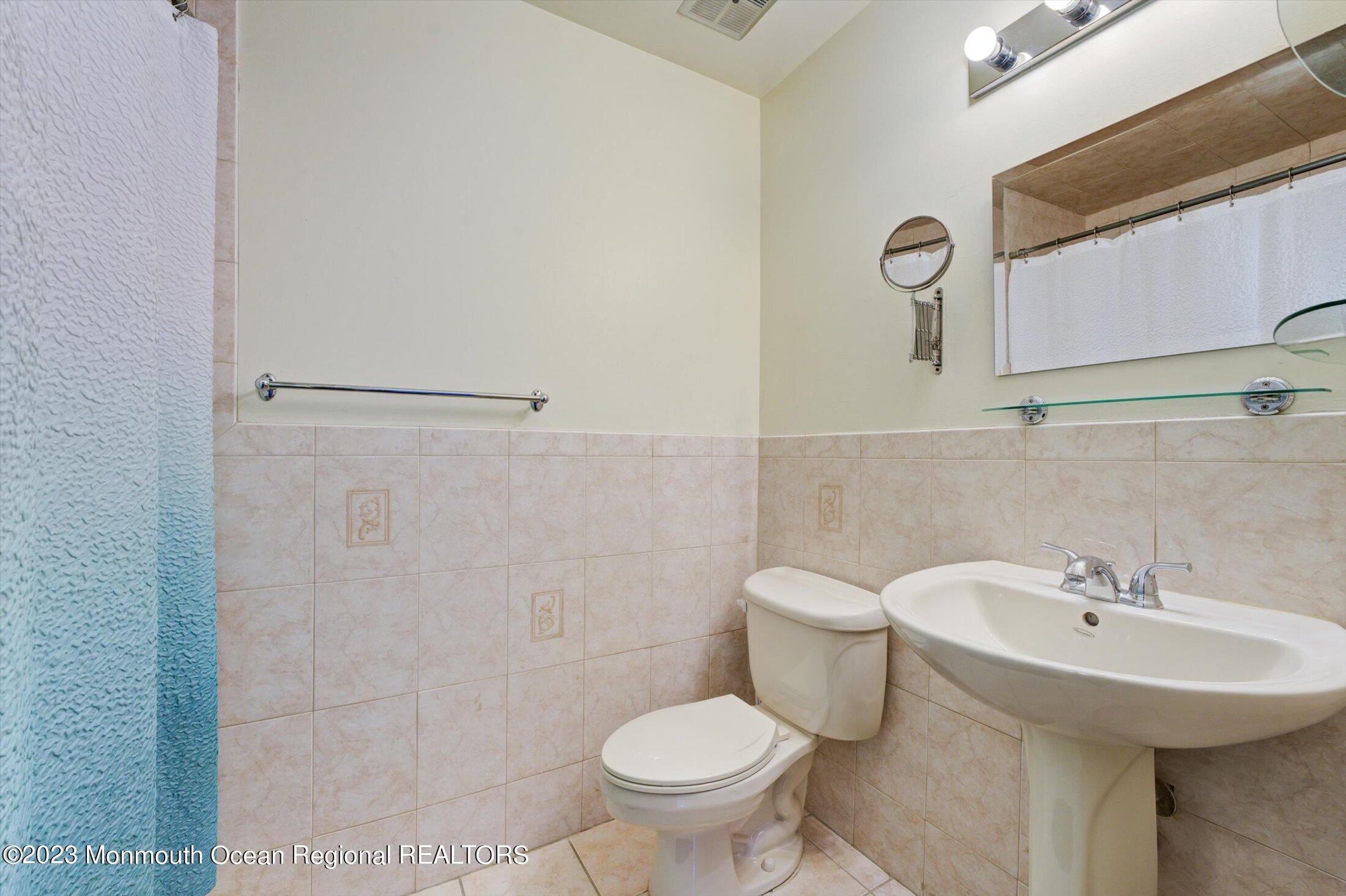 481 Hawthorne Place Morganville, NJ 07751 - Photo 22 of 26 a bathroom with a sink toilet and a mirror