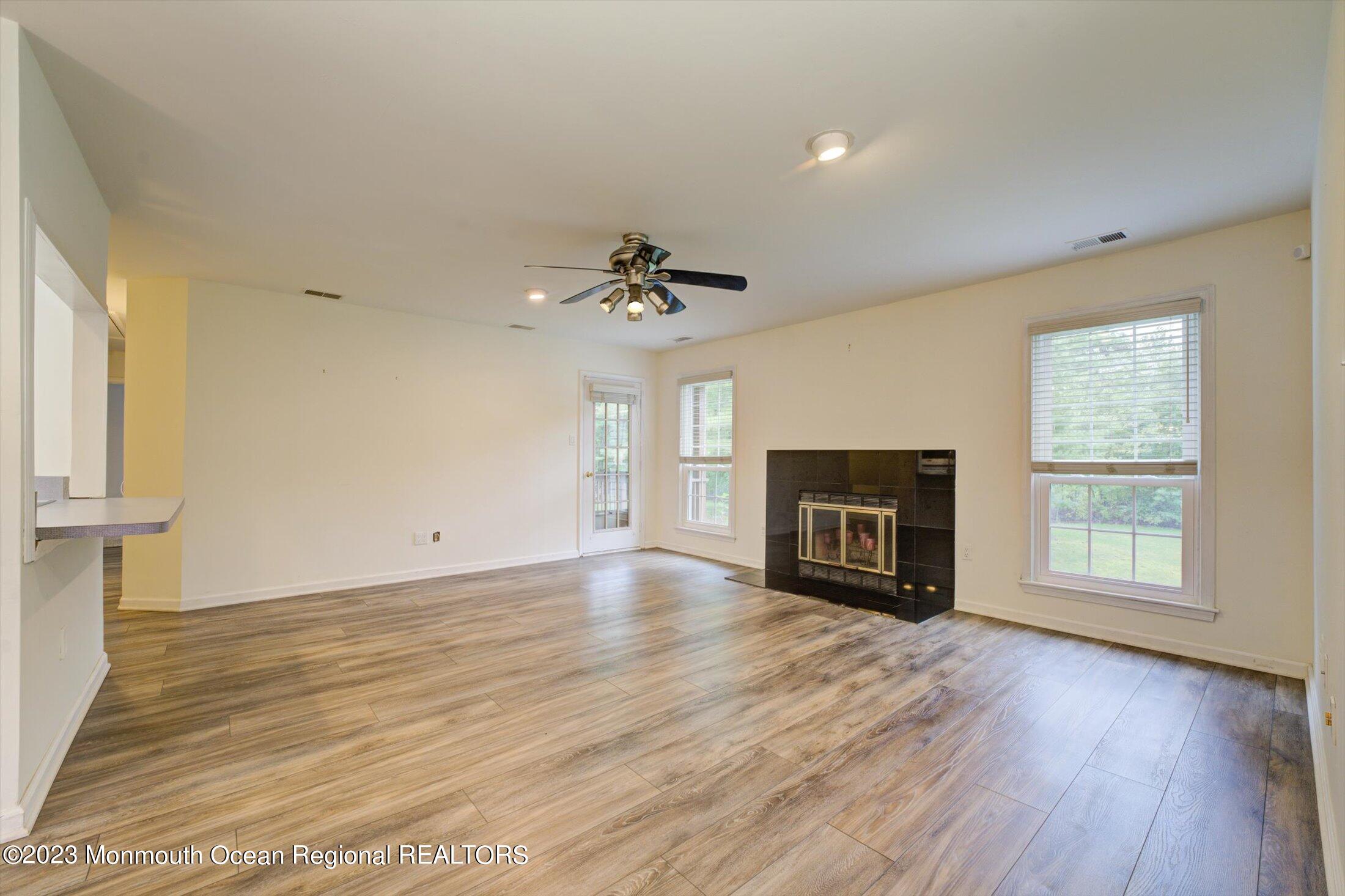 481 Hawthorne Place Morganville, NJ 07751 - Photo 4 of 26 a view of empty room with wooden floor and fireplace