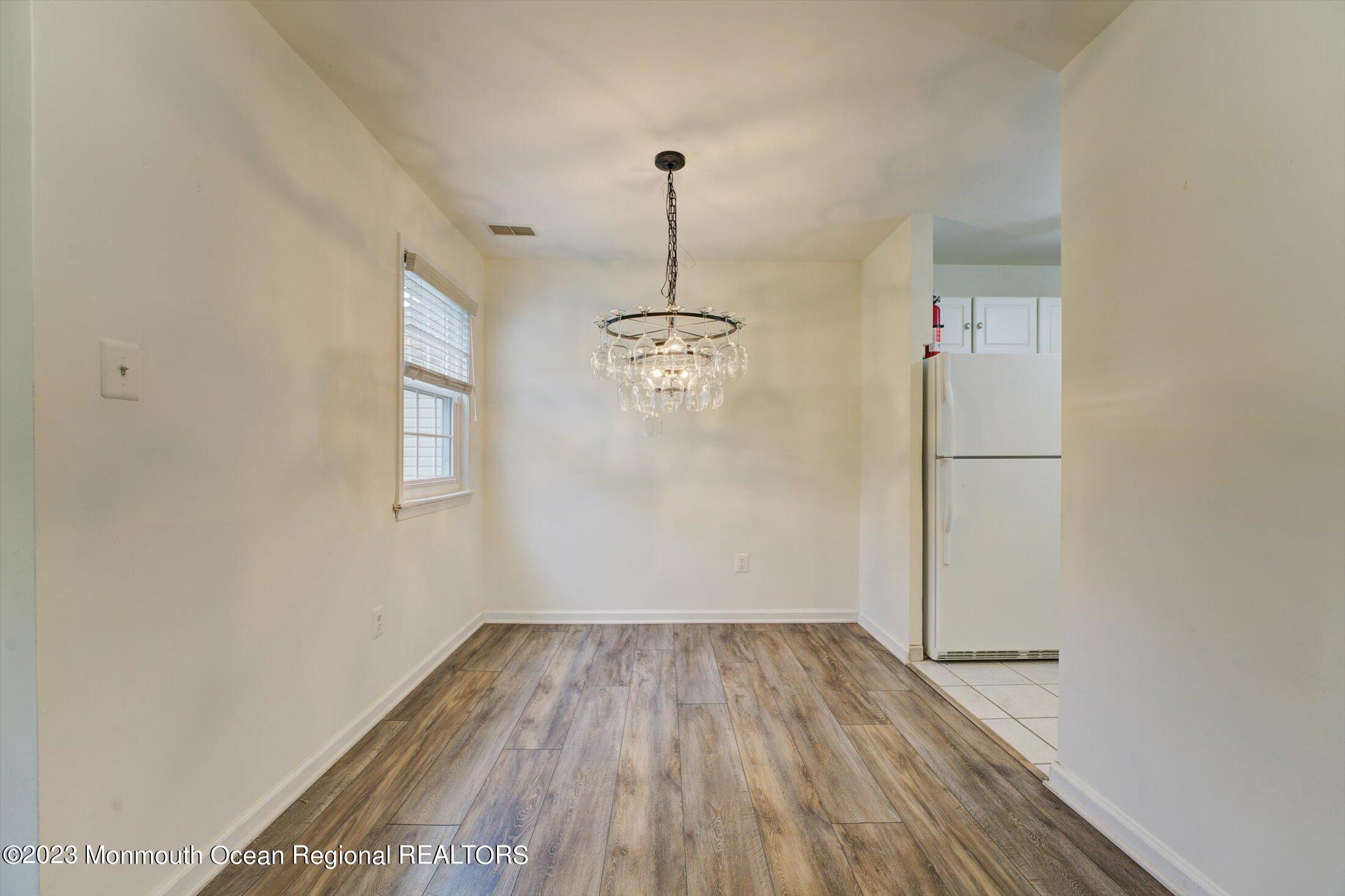 481 Hawthorne Place Morganville, NJ 07751 - Photo 10 of 26 a view of a room with wooden floor cabinets and a ceiling fan