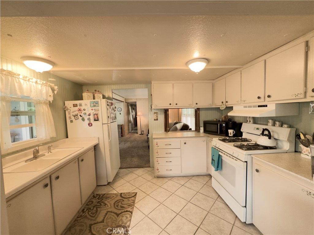 1255 Amethyst Street, Unit 44 Mentone, CA 92359 - Photo 12 of 27 a kitchen with white cabinets and white appliances
