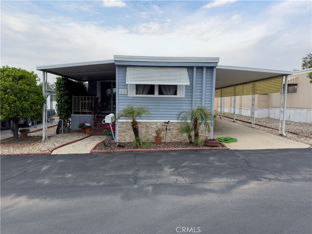 1255 Amethyst Street, Unit 44 Mentone, CA 92359 - Photo 2 of 27 a front view of a house with a yard and garage