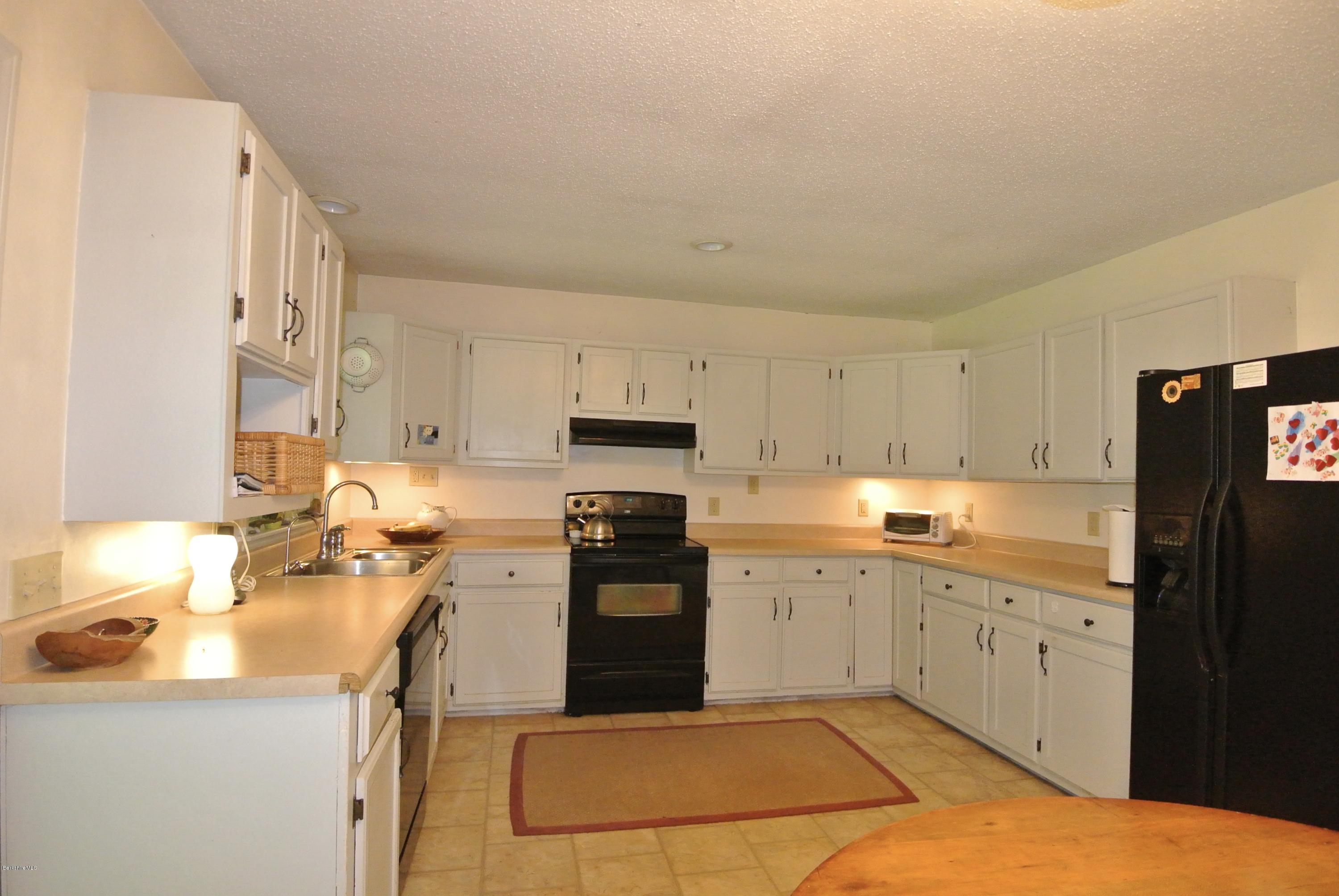 296 Salisbury Road Sheffield, MA 01257 - Photo 7 of 20 a kitchen with a sink window and cabinets