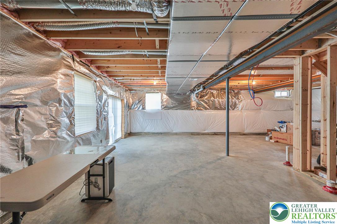 1105 Meco Road Easton, PA 18040 - Photo 40 of 100 An expansive unfinished walk-out basement features exposed wood framing and durable concrete flooring.