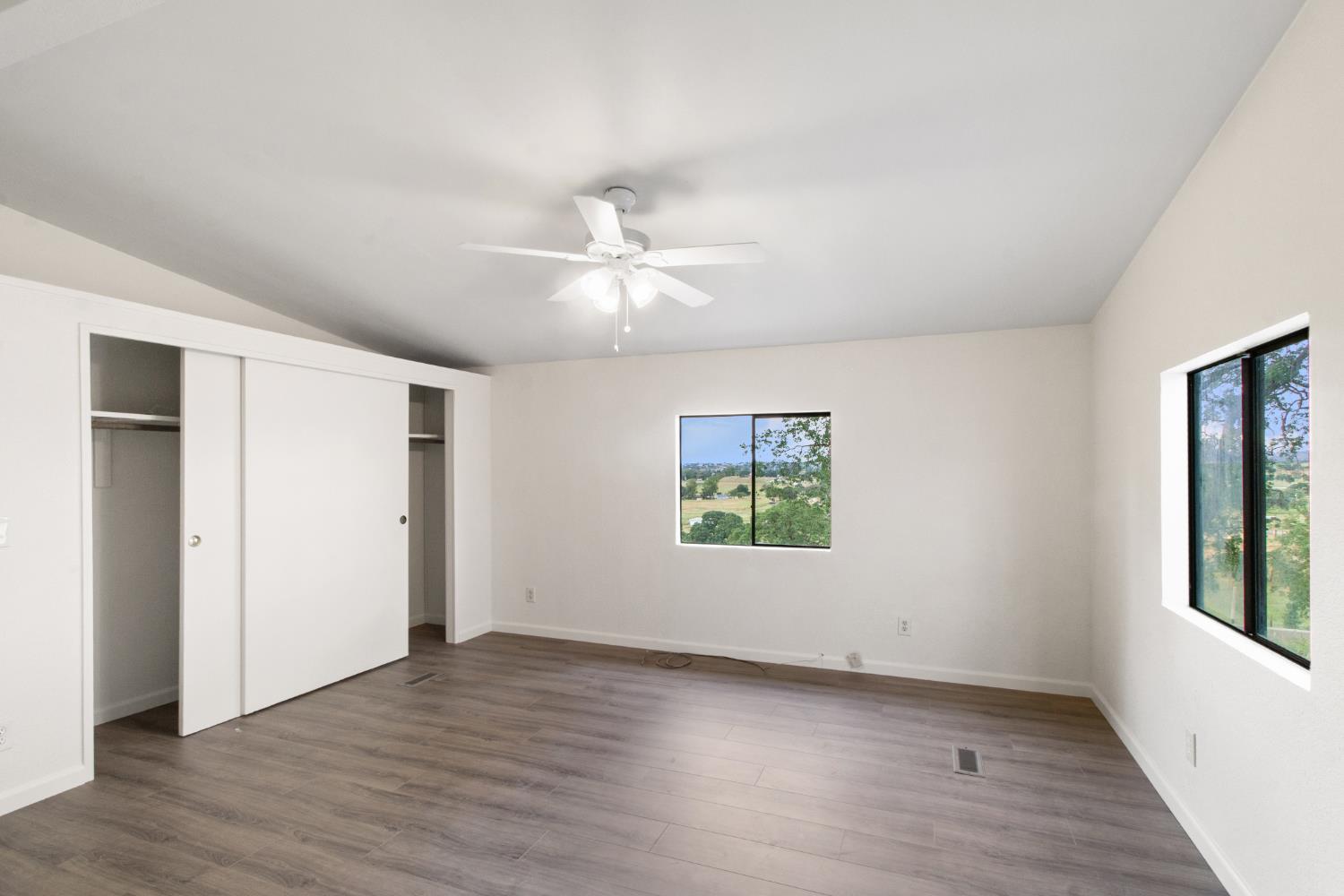 10580 Thompson Way Valley Springs, CA 95252 - Photo 21 of 64 an empty room with wooden floor ceiling fan and windows