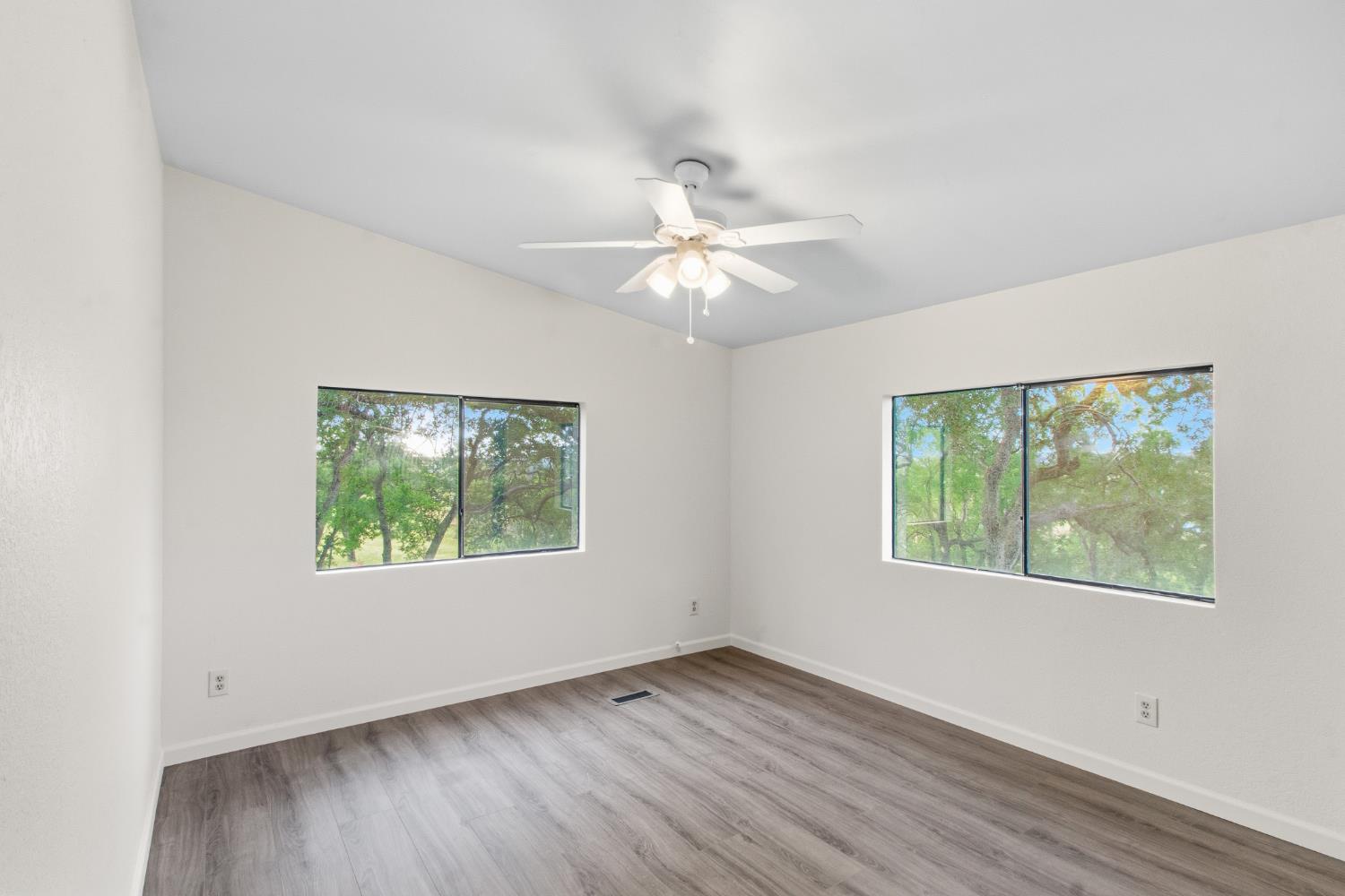 10580 Thompson Way Valley Springs, CA 95252 - Photo 24 of 64 a view of an empty room with wooden floor and a window