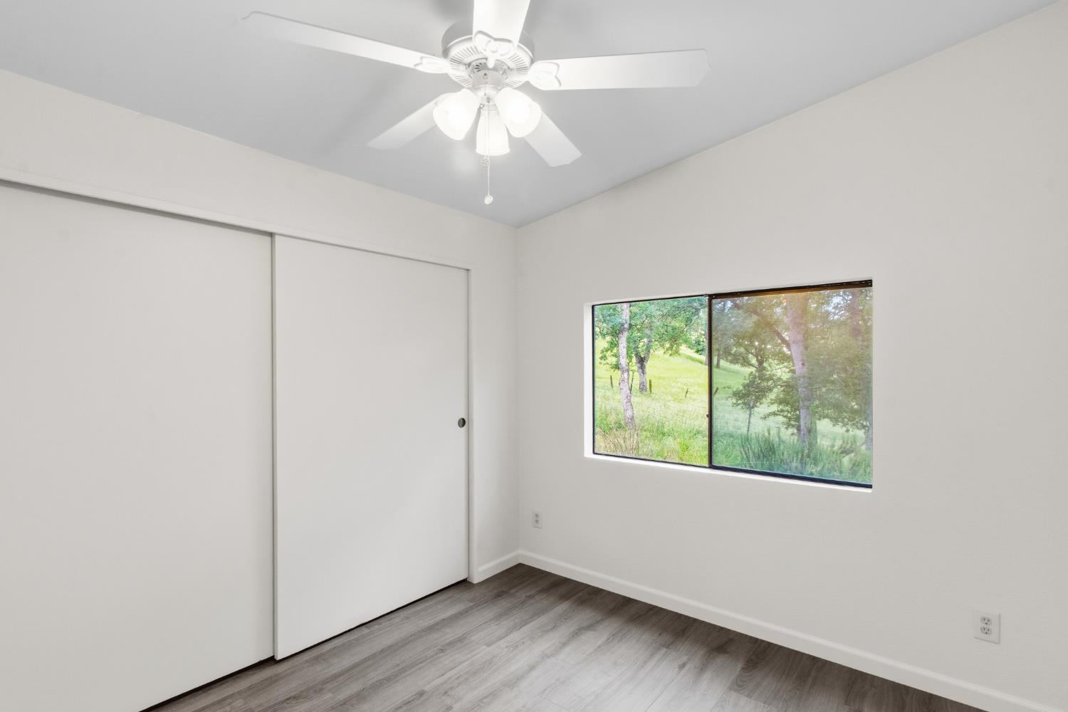 10580 Thompson Way Valley Springs, CA 95252 - Photo 25 of 64 an empty room with wooden floor fan and windows