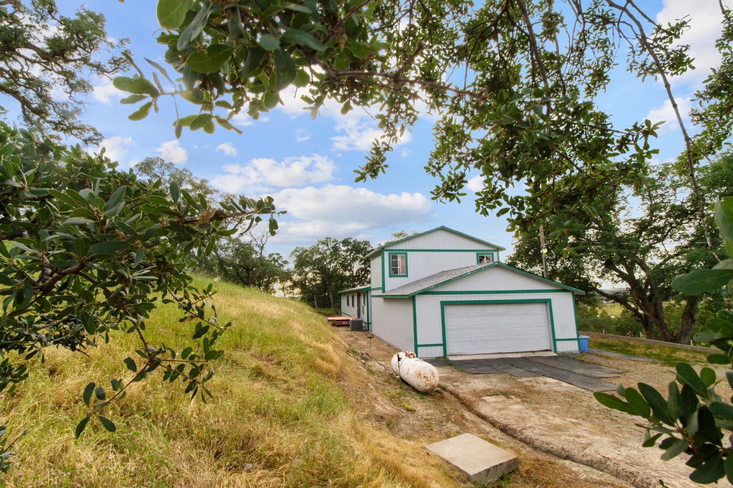 10580 Thompson Way Valley Springs, CA 95252 - Photo 49 of 64 a yellow house with trees in front of it