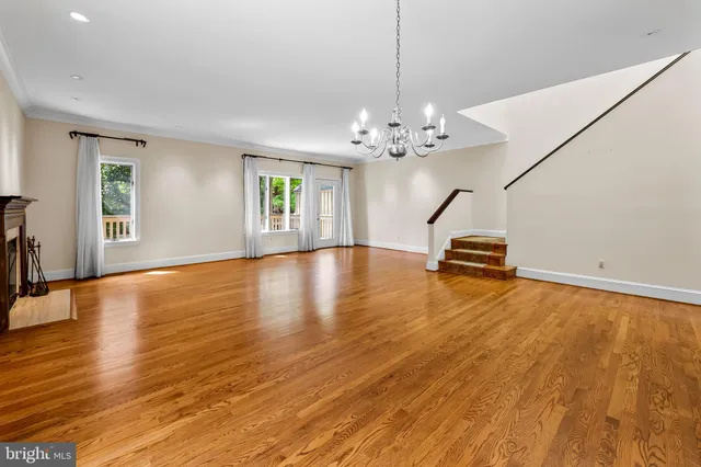 a view of empty room with wooden floor and window