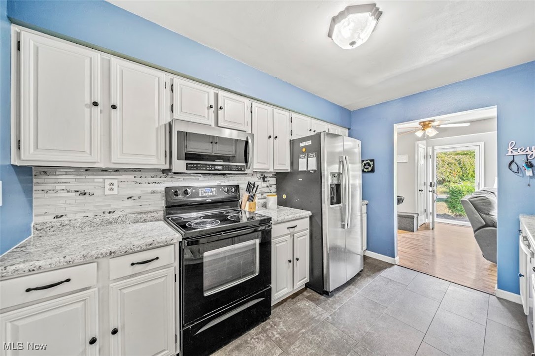 1864 Green Road Madison, OH 44057 - Photo 12 of 29 Kitchen featuring appliances with stainless steel finishes, decorative backsplash, white cabinetry, and ceiling fan