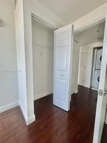 an empty room with wooden floor and closet