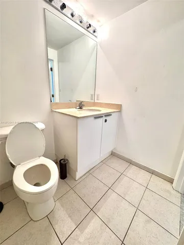 a bathroom with a granite countertop sink toilet a mirror and shower