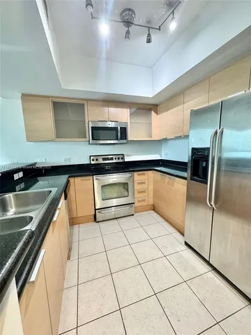 a kitchen with stainless steel appliances granite countertop a sink and a stove