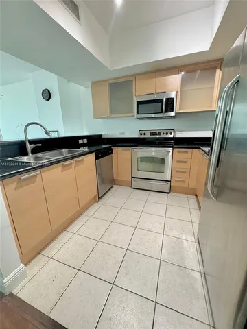 a kitchen with stainless steel appliances granite countertop a sink and a stove