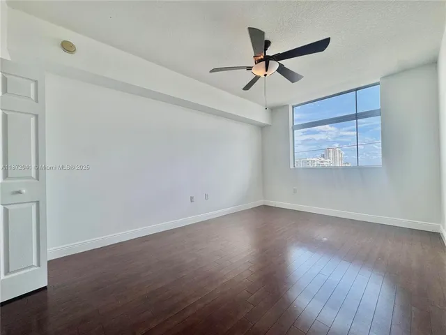 a view of a livingroom with a ceiling fan and wooden floor
