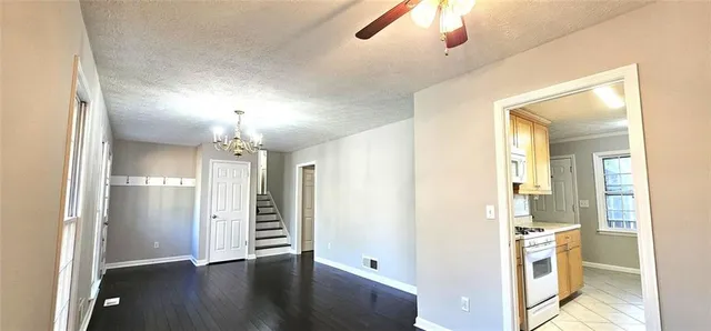 a view of a hallway with wooden floor and a kitchen
