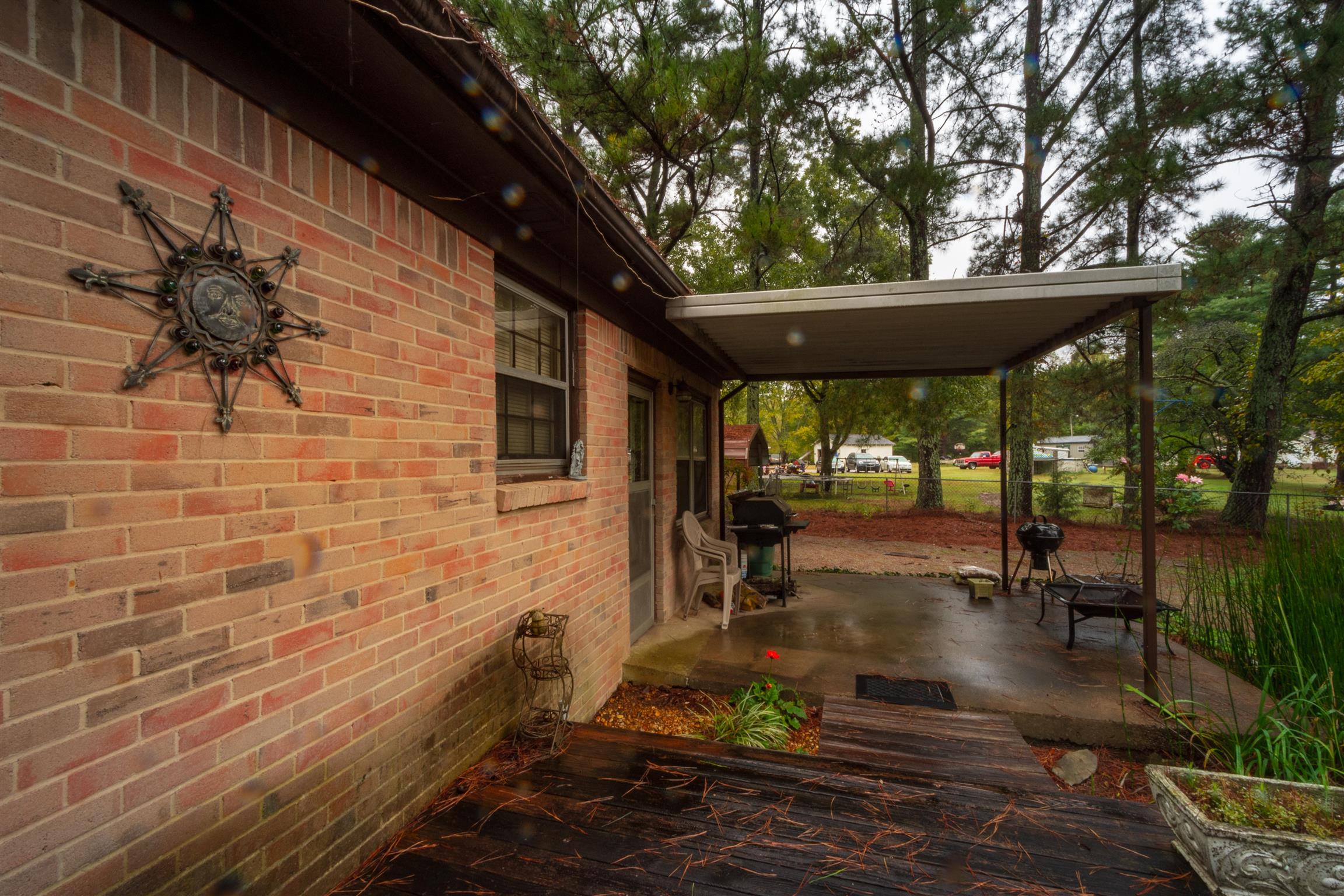 1309 Oak Grove Road Goodspring, TN 38460 - Photo 25 of 29 a view of a patio with table and chairs potted plants and large tree