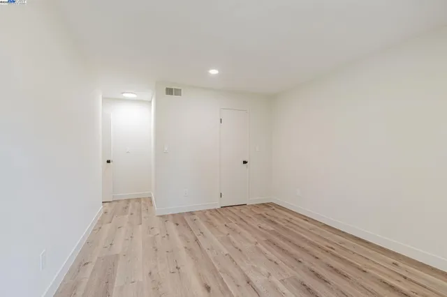 a view of room with wooden floor and white walls