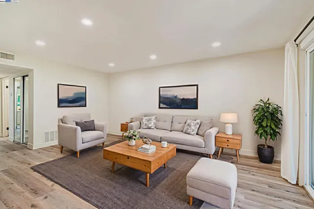 a living room with furniture and wooden floor