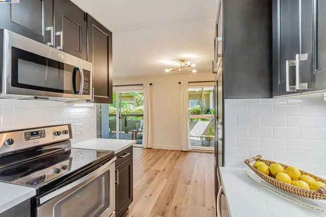 a kitchen with stainless steel appliances a stove microwave and refrigerator