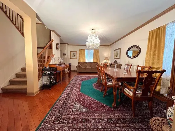 a living room with furniture a chandelier and a dining table